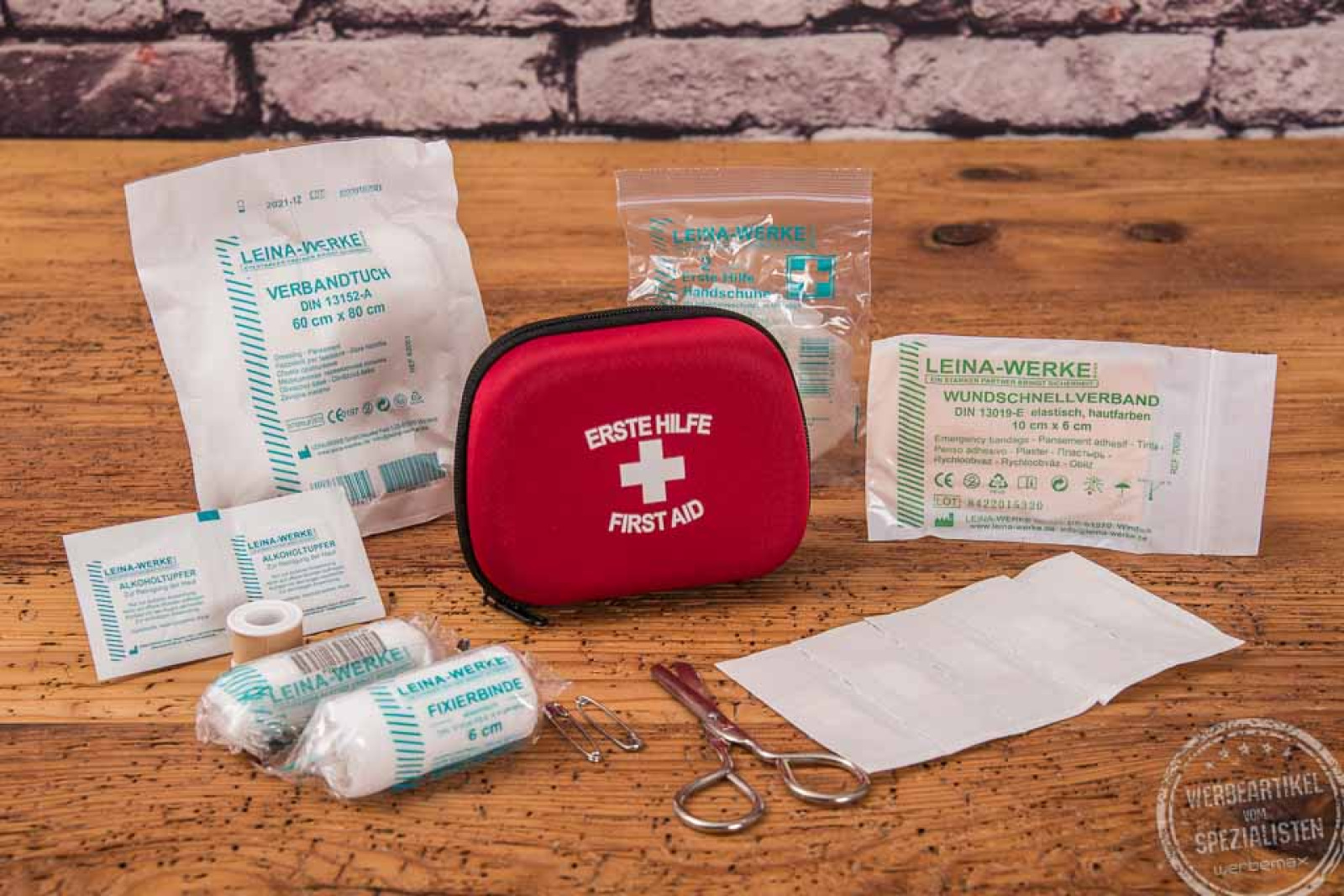 Rotes Erste Hilfe Set als Werbeartikel mit Klebeband, Schere, Fixierbinde, Wundschnellverband und Alkoholtupfer 