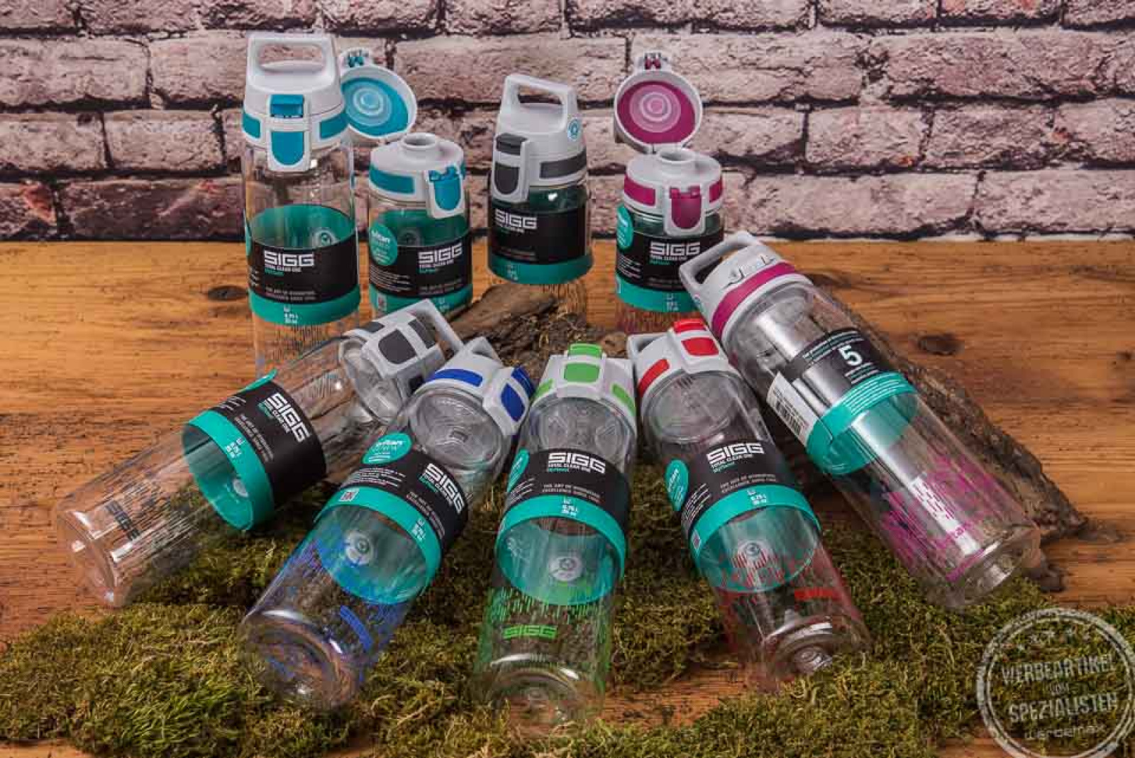 Liegende und stehende Sigg Trinkflaschen Total clear One MyPlanet mit unterschiedlichen Deckelfarben als Werbeartikel. 