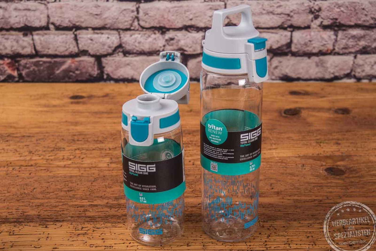 Zwei stehende Sigg Trinkflaschen Total Clear One MyPlanet mit geöffnetem Ein-Hand-Verschluss in grüner Farbe.